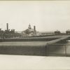 A view of an Ellis Island pier; the boat docked here is marked 'Ellis Island' and 'Department of Commerce and Labor.'