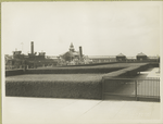 A view of an Ellis Island pier; the boat docked here is marked 'Ellis Island' and 'Department of Commerce and Labor.'