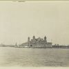 A view of Ellis Island taken from the harbor. At the center is the A Immigration Station; one of the boats in the pier is the John E. Moore.