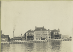 Another view of Ellis Island from the harbor, showing various buildings.