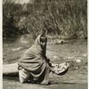 Taos, N.M., girl washing an Apache basket, 1926.