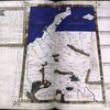 Fourth map of Europe (Germany) in gold border. Commentary text in brown border with gold rubrics and 4-line gold initial on blue and green field