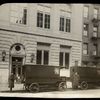 Two book vans waiting outside library, with drivers standing by, ca. 1920s
