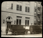 Two book vans waiting outside library, with drivers standing by, ca. 1920s