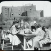 Corlear's Hook Park : older girl with books on one side of table in playground, other children on the other side