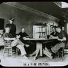 Fire house : men in a firehouse sitting around table reading, case for Traveling Library between them