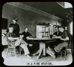 Fire house : men in a firehouse sitting around table reading, case for Traveling Library between them