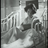 Post Graduate Hospital : girl in bed looks up from book, 1923