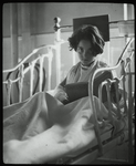 Post Graduate Hospital : girl in bed looks up from book, 1923