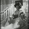 Post Graduate Hospital : girl in bed looks up from book, 1923.