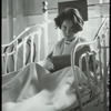 Post Graduate Hospital : girl in bed looks up from book, 1923
