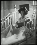 Post Graduate Hospital : girl in bed looks up from book, 1923