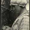 Woman in mob cap, with knitting yarn on a reel in the background