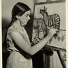 Girl drawing two zebras, using charcoal and easel