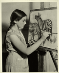 Girl drawing two zebras, using charcoal and easel