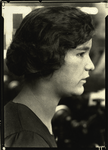 Pensive woman, with a lathe-like spinning machine in background