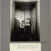 Boy in old-time tenement gets the water for his family from a community spigot in the hall, East Side, New York City, 1909