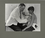 This boy is having a health examination to determine whether he is physically fit for work, June 1924