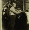 Man standing at machine with disks and webbed belt