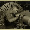 Man with micrometer measuring the steel shaft of a large machine...