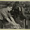 Workman replacing an empty shuttle with a full one in this power loom