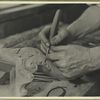 Hands of a wood carver putting finishing touches on a Chippendale chair or table leg
