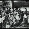 Work with schools, Hudson Park Branch : men look on as children are read to in the park, ca. 1910