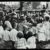 Work with schools, Hudson Park Branch : children gathered around librarian who is reading in the park, ca. 1910s
