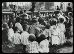 Work with schools, Hudson Park Branch : children gathered around librarian who is reading in the park, ca. 1910s