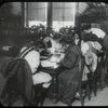 Work with schools, Tompkins Square : girls working at table : a class visit, 1910s