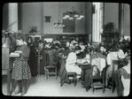 Work with schools, Tompkins Square : class from P.S. looking up N.Y. City history, Revolutionary period, one girl at card catalog, ca. 1910