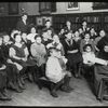 Work with schools : a librarian's assistant telling a story to a group of Russian children in their native language, ca. 1910s