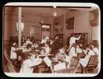 Work with schools : children's room : children at tables and choosing books from shelves, ca. 1920