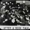 Work with schools : after a book talk, showing boys gathered around table reading, ca. 1920s.
