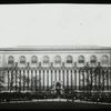 Central building, exterior views : Bryant Park facade from the park, fountain and Bryant Monument in center, people on benches, 1915.
