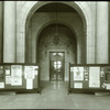 Central building, first floor lobby : looking from lobby (Astor Hall) toward exhibition hall, war posters (?) displayed on either side, ca. 1918