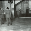 Central building, guards : the inspection at the door of visitor's books, parcels, etc.  Flannagan is the guard, Sept. 1913