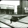 Central building : roof showing new skylight as installed (illustrating the use of the camera in job reporting), man standing on roof, view to the northeast?