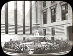 Central building, sculpture and monuments : interior court, midsummer 1912, showing fountain in center of court surrounded by plants.
