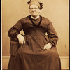 Portrait of seated woman wearing a headwrap.