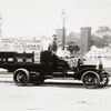 Truck with sign reading Rapid 4 Cylinder with driver and two passengers