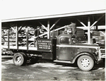 Model T 18 #C G 26  with lettering R.E. Behnke Lumber Co.; two people loading lumber