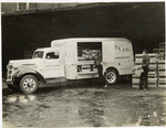 Model T 16 - A 7; people loading crates filled with bottles