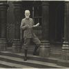 Bernard Shaw on the steps with a news-paper in his hands.