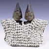 A pair of Ibeji twin figures with a cowrie-shell coat