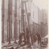 Workers erecting metal columns and a pulley