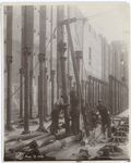 Workers erecting metal columns and a pulley