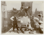 Exterior marble work : construction workers positioning a piece of marble on the roof, looking east