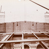 Interior work : marble covering part of a brick wall, with exposed structural framework in the foreground