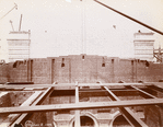 Interior work : marble covering part of a brick wall, with exposed structural framework in the foreground